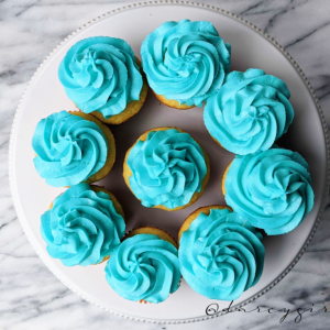 A plate of cupcakes with blue frosting