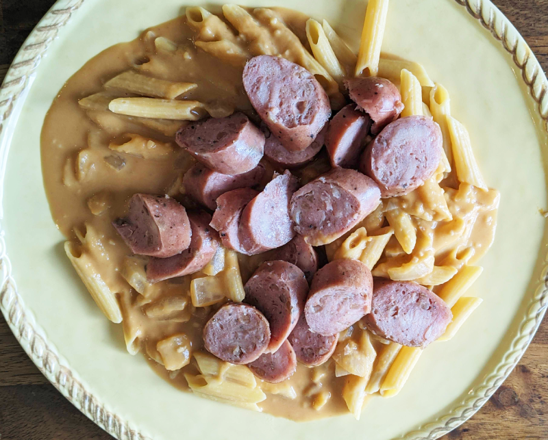 Dairy-free pumpkin alfredo sauce over penne pasta and chicken sausage on top. 